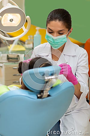 Serious concentrated female dentist performing a dental examination Stock Photo