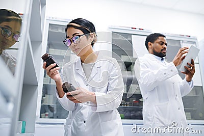 Pharmacist finding necessary pills in storage room Stock Photo