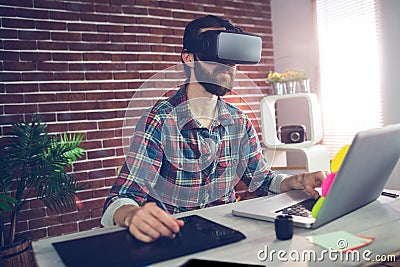 Serious creative businessman using 3D video glasses and laptop Stock Photo