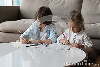 Serious cute little sibling children drawing in coloring pencils Stock Photo