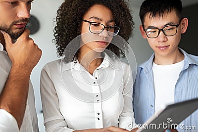 Serious diverse programmers using tablet Stock Photo