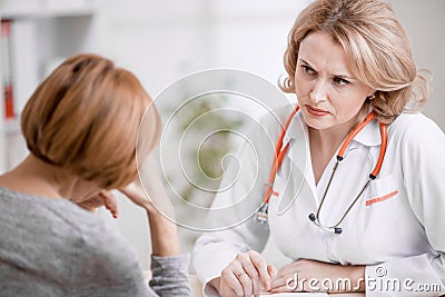 Serious doctor or physician looking at upset Stock Photo