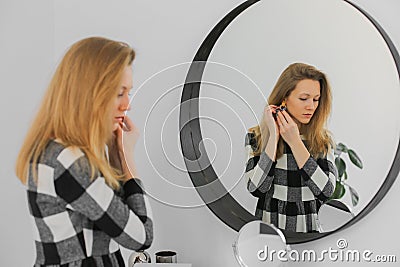 Serious elegant woman near mirror Stock Photo