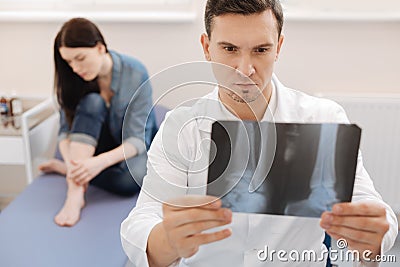 Serious experienced rheumatologist holding an X ray image Stock Photo