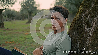 Serious farmer relaxing nature portrait. Calm man posing at olive tree close up Stock Photo