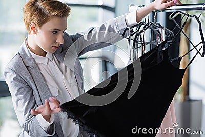 serious fashion designer examining quality of clothing Stock Photo