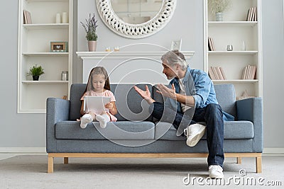 Serious father scolding little daughter in home interior. Stock Photo