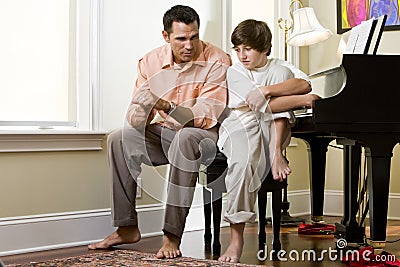 Serious father talking to teenage son at home Stock Photo