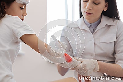 Serious female doctor stopping bleeding Stock Photo
