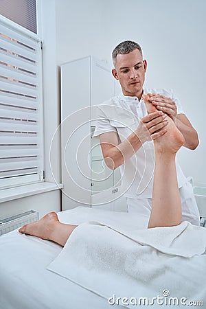 Experienced concentrated physiotherapist using an acupressure massage Stock Photo