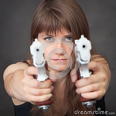 Serious girl aims from two pistols close up Stock Photo