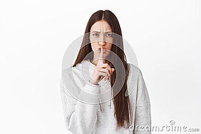 Serious girl tell to be quiet. Woman shushing and making taboo sign, keep secret, behave yourself, silence please Stock Photo