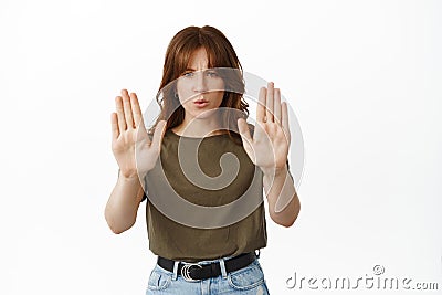Serious girl tell to stop, say no, refuse or forbid action, raising palms up to make block, prohibit something bad Stock Photo