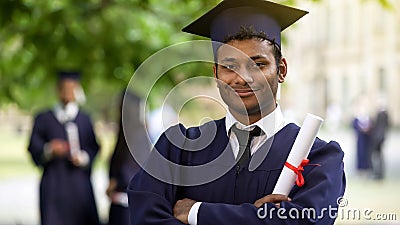 Serious graduate crossing arms with diploma in hand, completion of studies pride Stock Photo