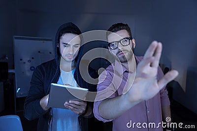 Serious handsome colleagues working on a sensory screen Stock Photo