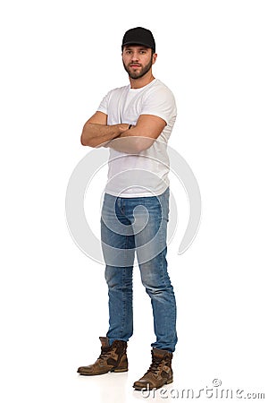 Serious Handsome Man In Black Cap Is Standing With Arms Crossed Stock Photo