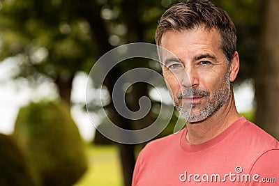 A serious handsome Mature Man looking At The Camera. Outside Stock Photo