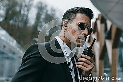 serious handsome security guard talking Stock Photo