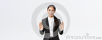 Serious-looking displeased asian female manager, businesswoman in black suit stop action, prohibit or restrict something Stock Photo