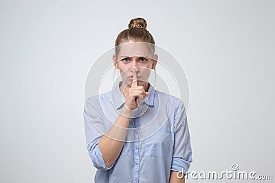 Serious lovely woman asks to keep secret information confidential Stock Photo