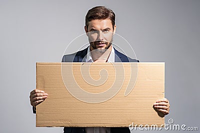 Serious man holds the sign, blank card. Placard ready for your product. Sign to your text. Handsome man showing blank Stock Photo