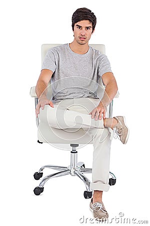 Serious man sitting on a swivel chair Stock Photo