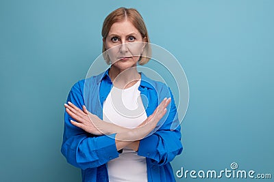 serious mature woman disagree on blue background with copyspace Stock Photo