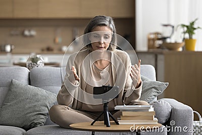 Serious mature woman recording videoblog at home Stock Photo