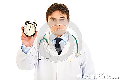 Serious medical doctor holding alarm clock in hand Stock Photo