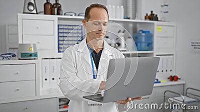 Serious middle age man, a devoted scientist engrossed in groundbreaking research using tech-savvy laptop, engrossed in a medical Stock Photo