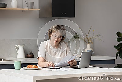 Serious middle aged landlady, homeowner woman calculating income Stock Photo