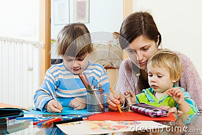 Serious mother and children sketching with pencils Stock Photo