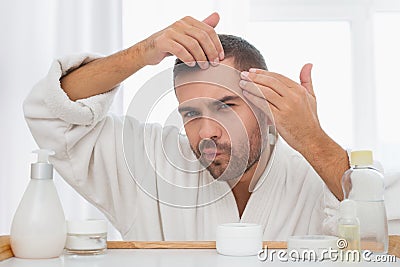 Serious nice man looking at his face Stock Photo