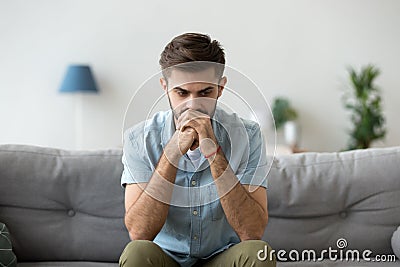 Serious pensive man sitting thinking at home Stock Photo