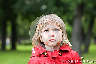Serious or sad baby girl in red. Caucasian blonde real people girl close portrait outdoor Stock Photo