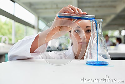 Serious science student pouring liquid Stock Photo