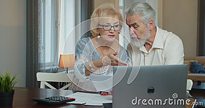 Serious senior old couple talking disputing holding paper bills checking finances expenses, older middle aged family Stock Photo