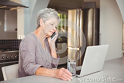 Serious senior woman talking on mobile phone Stock Photo