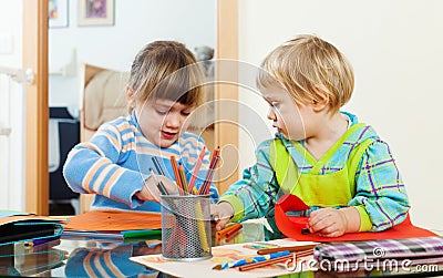 Serious siblings playing with pencils Stock Photo