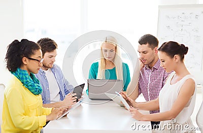 Serious team with table pc and laptop in office Stock Photo