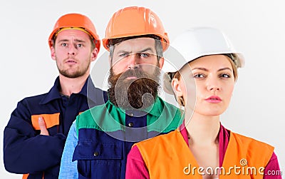Serious team of three constructor workers in hard hats Stock Photo