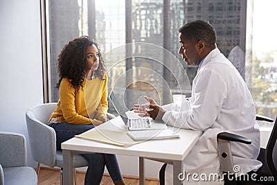 Serious Woman Having Consultation With Male Doctor In Hospital Office Stock Photo