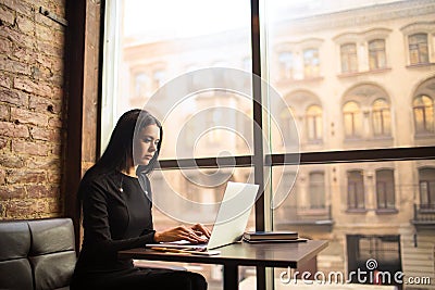 Serious woman professional marketing coordinator publication on web page resume while sitting in restaurant Stock Photo