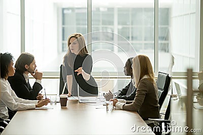 Serious woman boss talking to multiracial team at boardroom meet Stock Photo