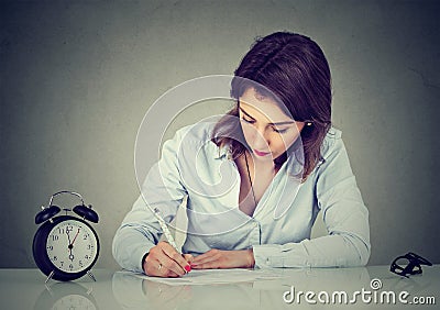 Serious young business woman writing a letter or filling out an application form Stock Photo