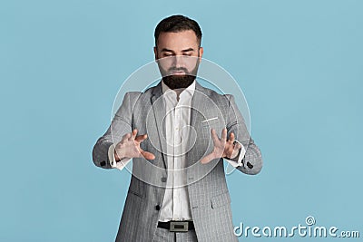 Serious young entrepreneur touching interactive virtual screen on blue background, space for design Stock Photo
