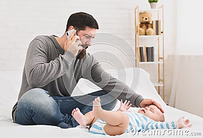 Serious young loving father touching his baby forehead Stock Photo