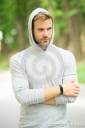 Seriousness and masculinity. sportswear fashion. sportsman relax after training outdoor. handsome unshaven man in hood Stock Photo