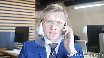 Seroius angry young businessman talking on a smartphone Stock Photo