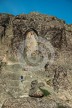 Image of Our Lady of the Good Star carved in cliff and man Editorial Stock Photo